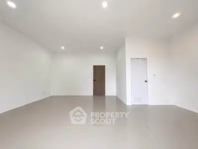 Spacious empty room with white walls and tiled floor, ideal for customization.