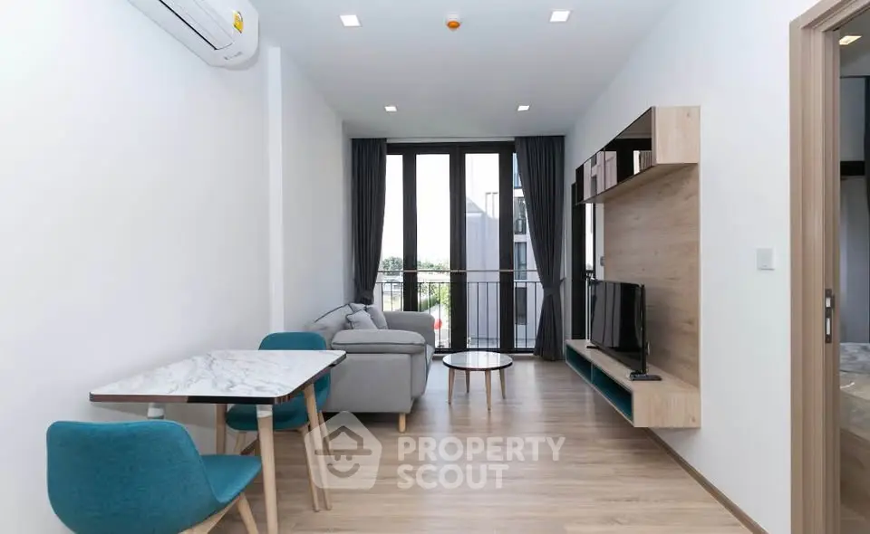 Modern living room with stylish furniture and large windows offering natural light and a cozy atmosphere.