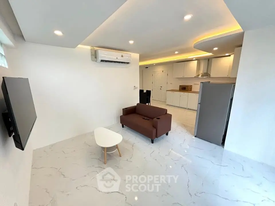Modern open-layout living room with sleek kitchen and stylish furniture