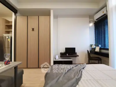 Modern bedroom with sleek design, featuring built-in wardrobe and cozy workspace by the window.