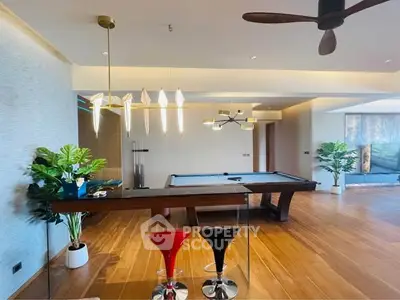 Luxurious living room with pool table and modern lighting, perfect for entertainment.