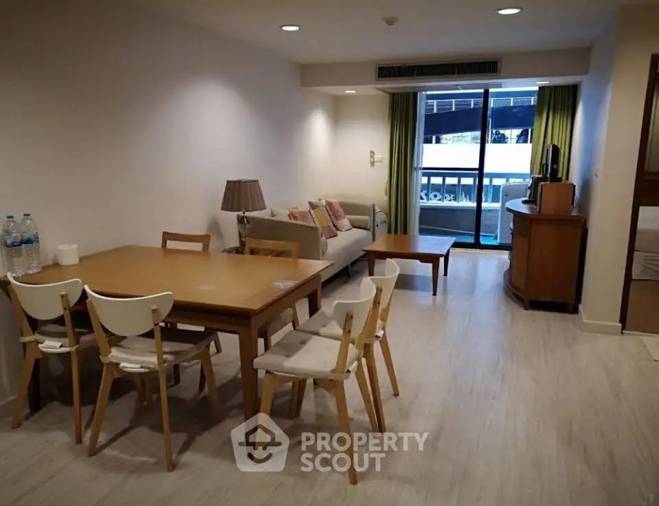 Spacious living room with dining area and balcony access in modern apartment.