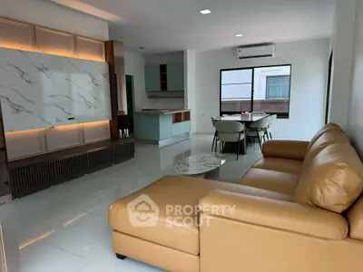 Spacious modern living room with elegant leather sofa and stylish open kitchen layout.