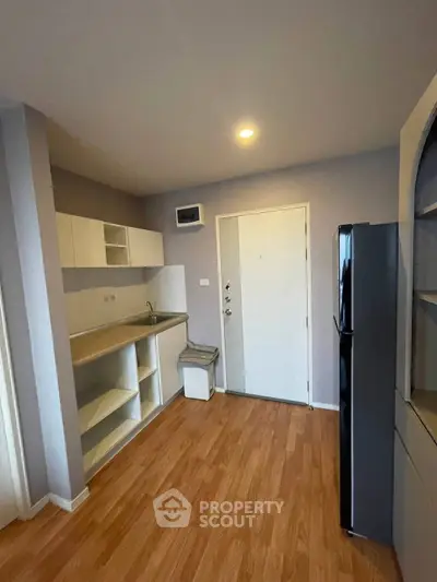 Modern compact kitchen with sleek cabinetry and hardwood flooring