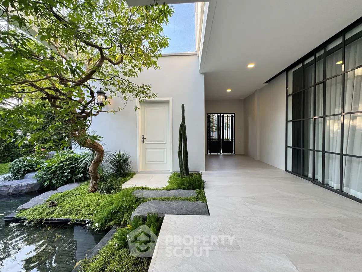 Elegant modern entrance with serene garden and water feature