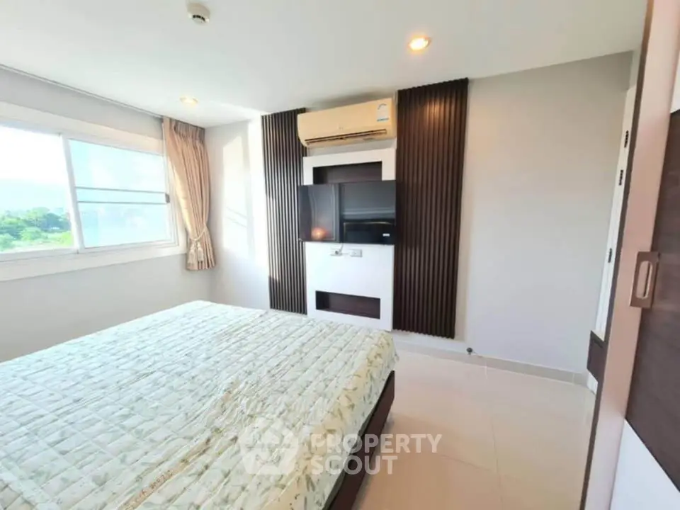 Bright and modern bedroom with large window and air conditioning unit.