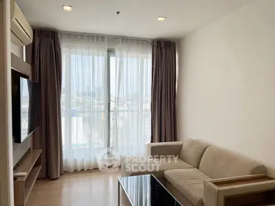 Modern living room with large window and cozy sofa in a bright apartment.
