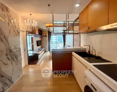 Luxurious modern apartment interior with open kitchen and elegant living area, featuring marble accents and chandelier.