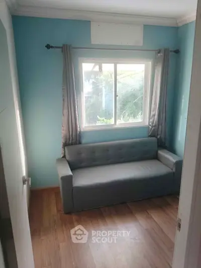 Cozy small room with a window view and a gray sofa, perfect for a compact living space.