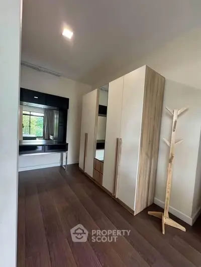 Spacious bedroom with modern wardrobe and elegant wooden flooring