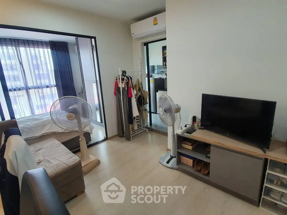 Modern apartment interior with cozy living area and bedroom, featuring natural light and stylish decor.