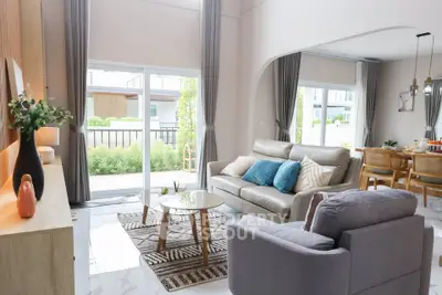 Spacious modern living room with elegant decor and large windows overlooking a lush garden.