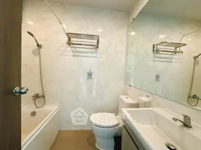 Modern bathroom with bathtub, sleek fixtures, and elegant marble walls.