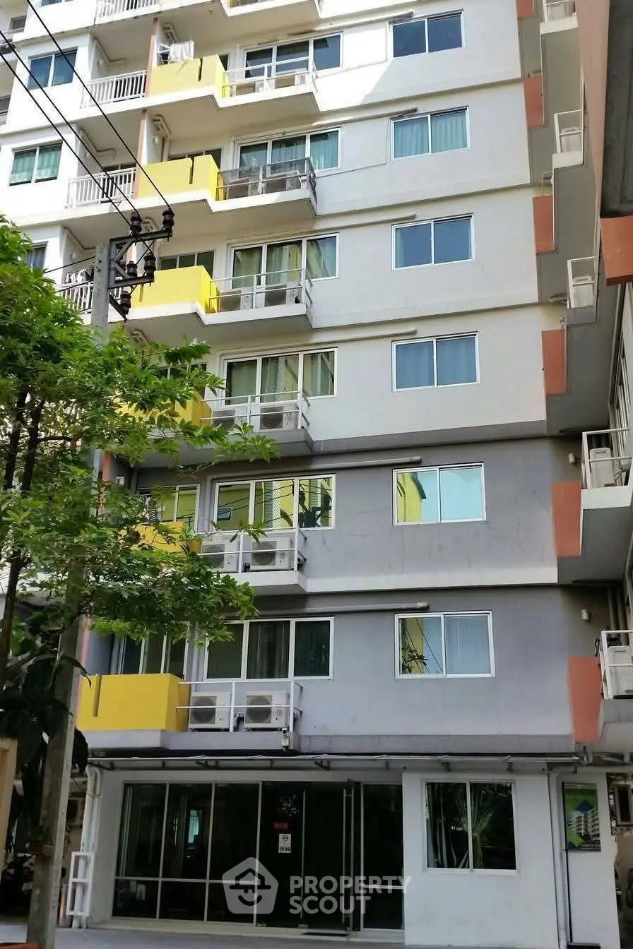 Modern multi-story apartment building with balconies and large windows.