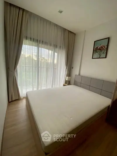 Spacious bedroom with large window and elegant decor in modern apartment