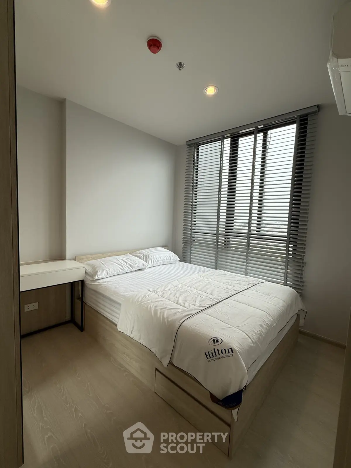 Modern bedroom with stylish blinds and cozy bed in a contemporary apartment.
