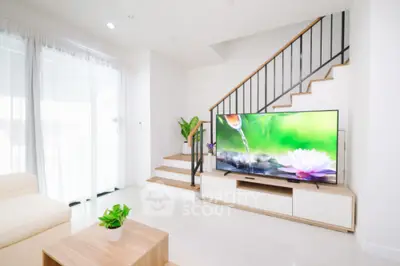 Modern living room with stylish staircase and large TV