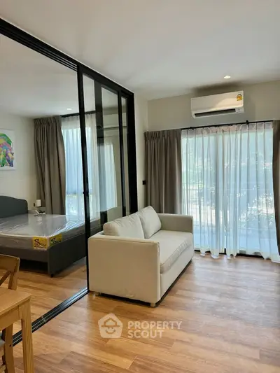 Modern living room with glass partition and cozy sofa in a bright apartment