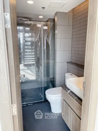 Modern bathroom with glass shower and sleek fixtures in a contemporary apartment.