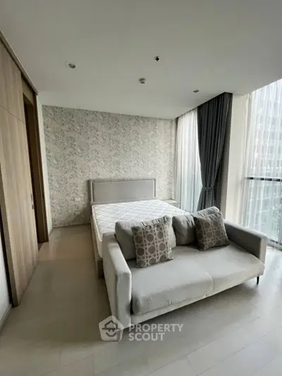 Spacious bedroom with elegant decor and large windows in modern apartment