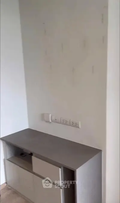 Minimalist interior with built-in storage and electrical outlets, perfect for modern living spaces.
