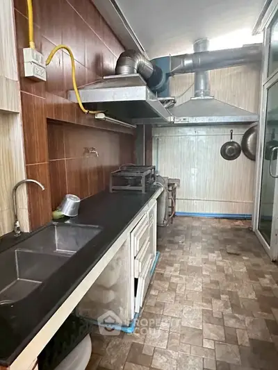 Spacious kitchen with gas stove and modern ventilation system