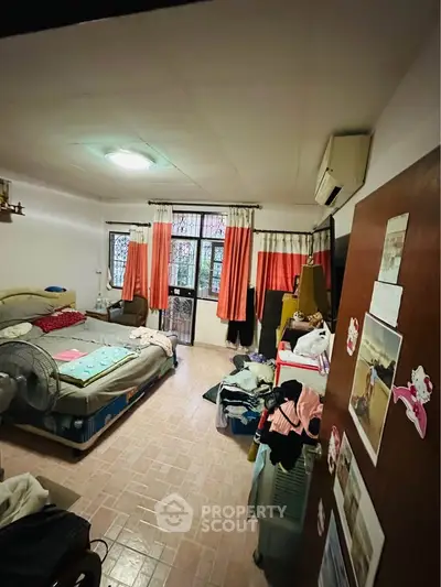 Cozy bedroom with air conditioning and natural light, featuring a comfortable bed and practical storage solutions.