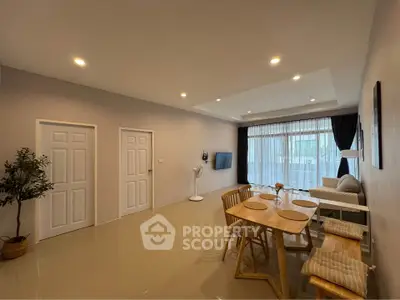 Spacious living room with modern dining area and natural light