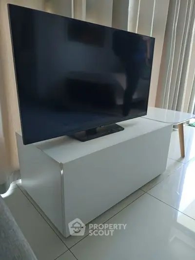 Modern living room with sleek TV stand and large flat-screen TV