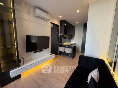 Modern living room with sleek design and open kitchen layout, featuring stylish furniture and ambient lighting.