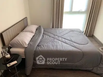 Cozy bedroom with modern decor and ample natural light, featuring a comfortable bed and stylish side table.