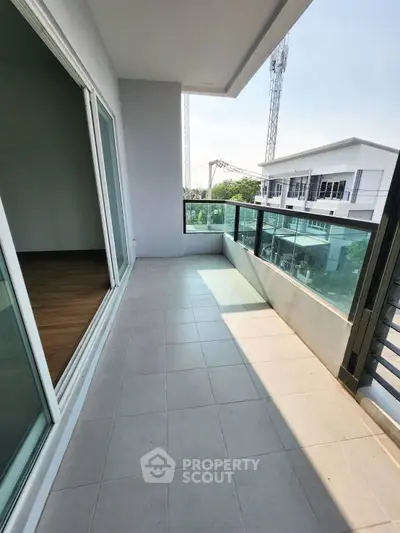 Spacious balcony with modern railing and city view, perfect for relaxation and outdoor enjoyment.