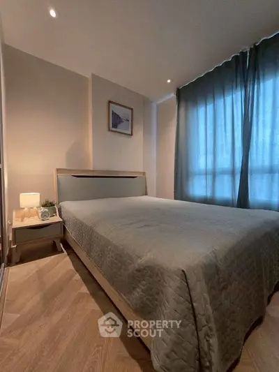 Cozy bedroom with modern decor and soft lighting, featuring a comfortable bed and stylish nightstand.