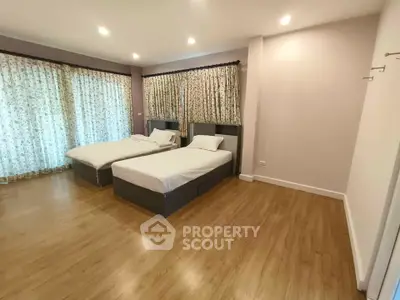 Spacious bedroom with twin beds and elegant wooden flooring