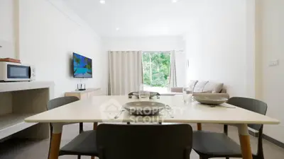 Modern living room with dining area and large window view, perfect for cozy gatherings.