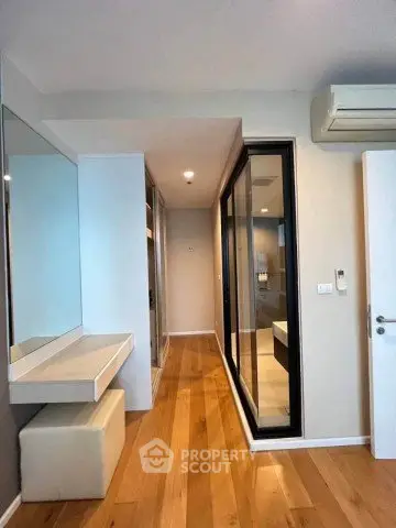 Modern hallway with wooden flooring and mirrored closet doors in a stylish apartment.