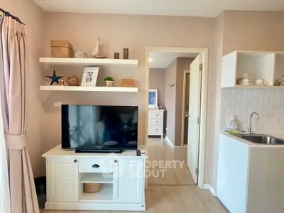 Charming living room with modern decor and wall-mounted TV in cozy apartment.