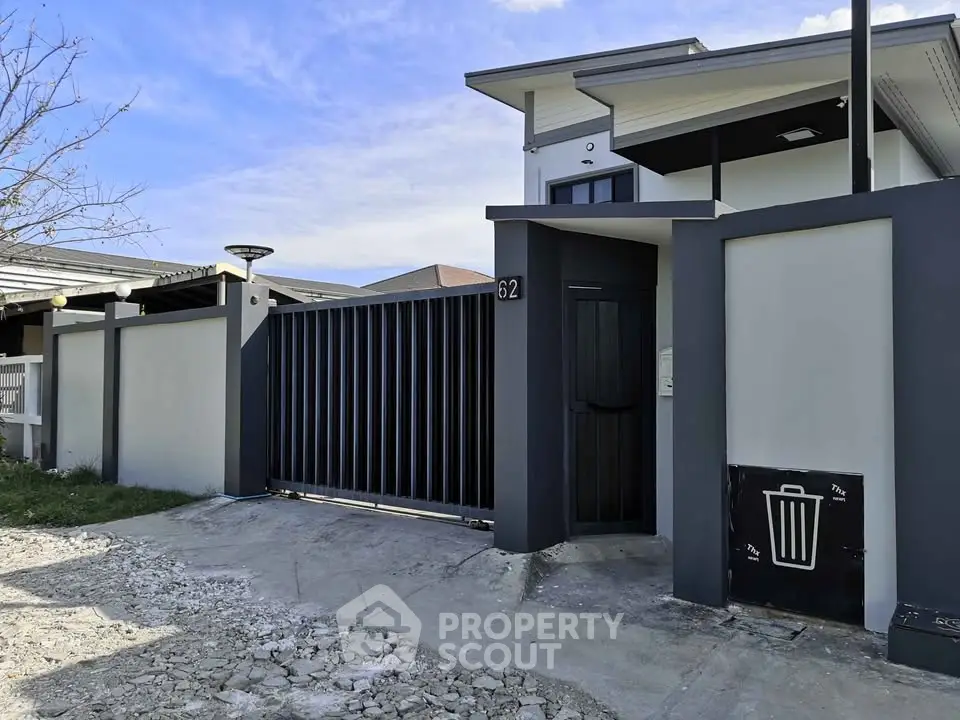 Modern residential building with sleek black gate and minimalist design.