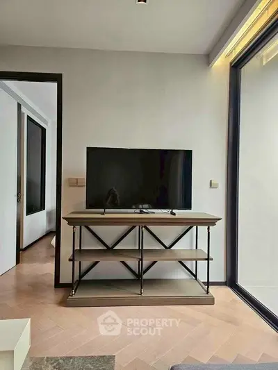 Modern living room with sleek TV stand and large window for natural light.