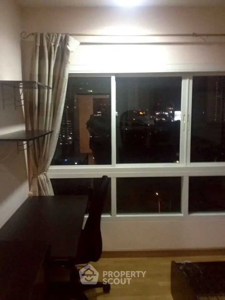 Cozy study room with night city view, featuring a desk and shelves, perfect for work or study.