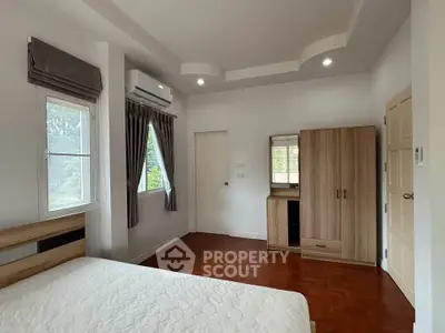 Spacious bedroom with modern furnishings and natural light in a stylish home.