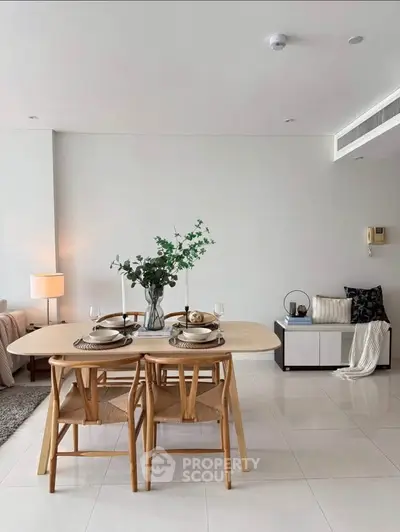 Modern dining area with elegant table setting and cozy seating in a stylish apartment.