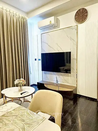 Elegant living room with modern decor, wall-mounted TV, and stylish furniture.