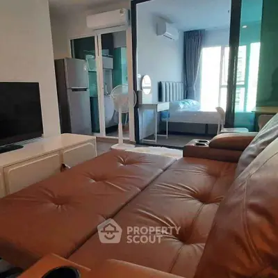 Modern apartment with cozy living room and bedroom, featuring sleek furniture and natural light.