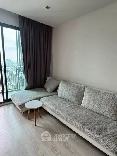 Modern living room with cozy gray sofa and city view balcony