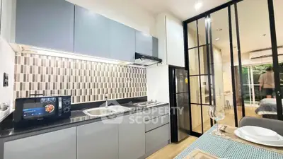 Modern kitchen with sleek cabinetry and dining area in stylish apartment