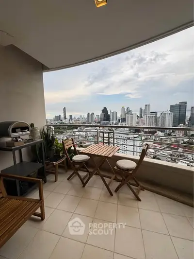 Stunning city view from a modern balcony with stylish outdoor seating, perfect for relaxation and entertainment.