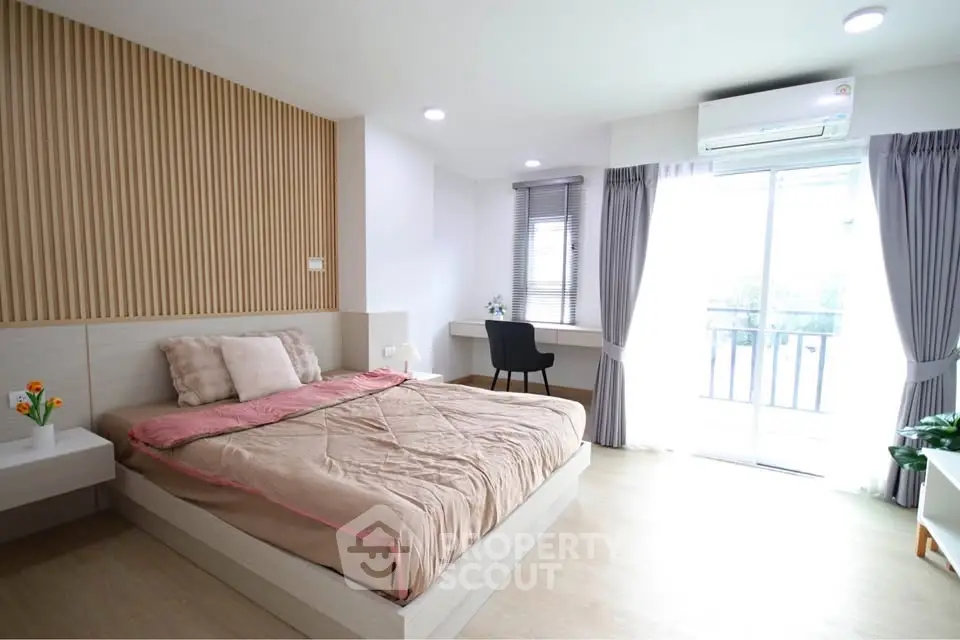 Modern bedroom with natural light, stylish decor, and balcony access.