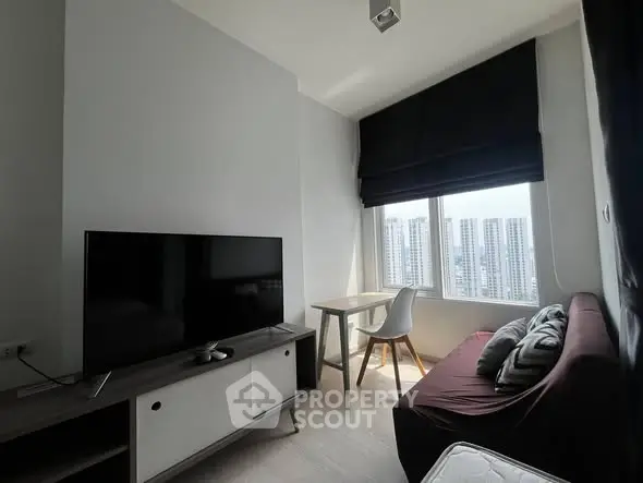 Modern living room with city view, featuring sleek furniture and natural light.
