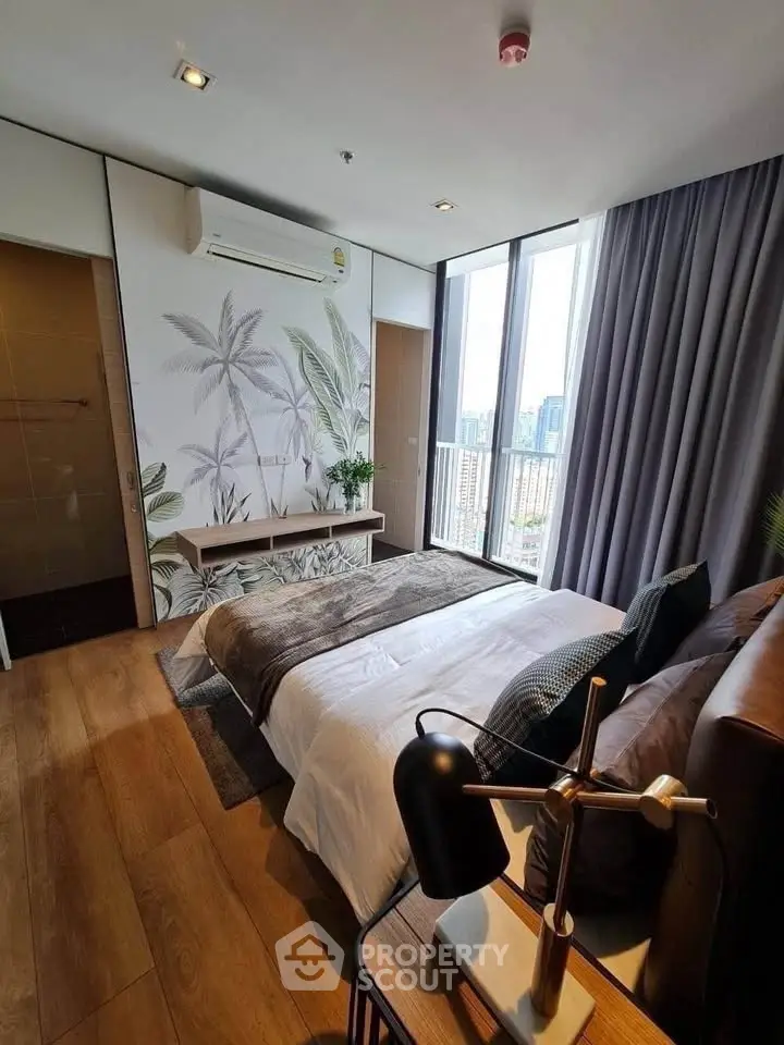 Luxurious bedroom with city view, elegant decor, and natural light in modern apartment.